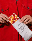 Person holding a chocolate bar with fruit pieces and macadamias