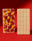 Two chocolate bars, one with fruit pieces and the other plain, on a red background