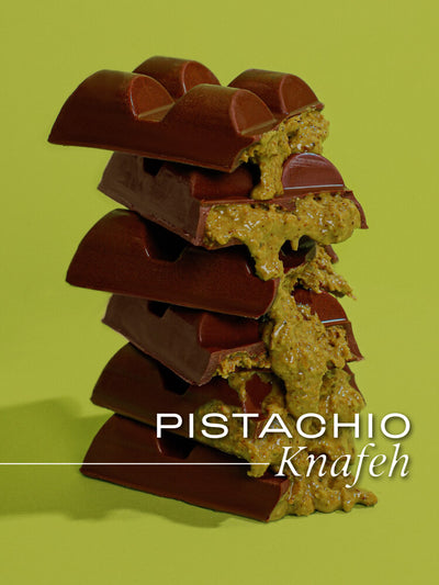 A stack of thick pistachio knafeh chocolate bars with a green background, the bars are broken to show the pistachio filling.