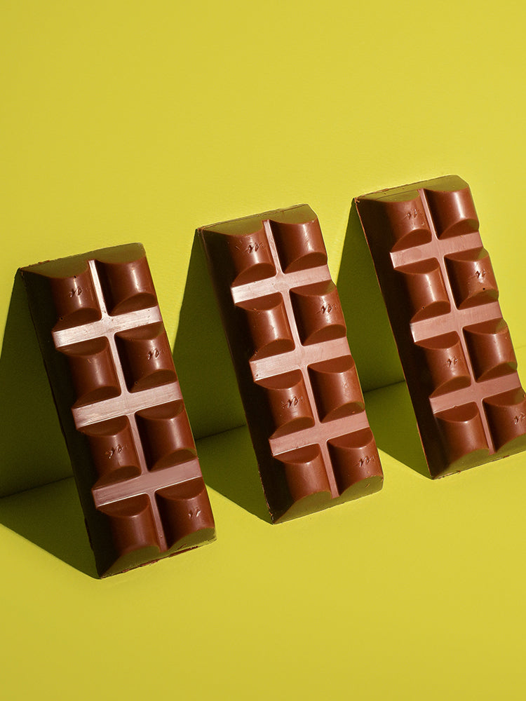 Three chocolate bars arranged in a row on a green background
