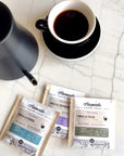 The 3 Honesto Coffee drips next to a cup of brewed coffee