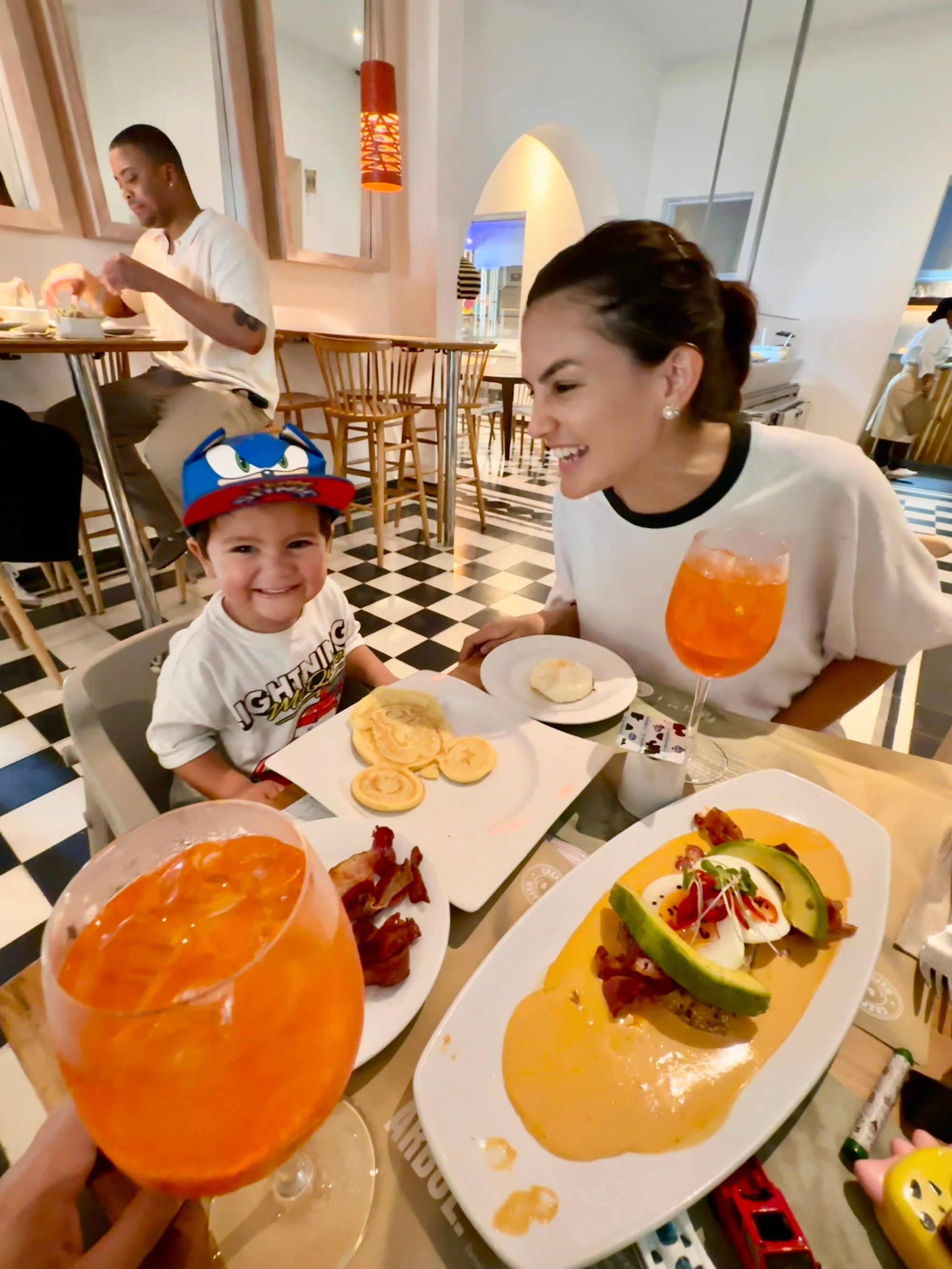 Brunch at Crepes in cartagena with plates on table, spritzers and a Mickey Mouse waffle