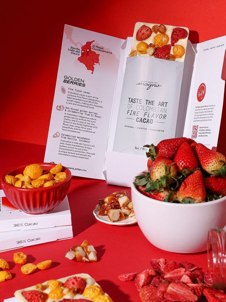 Assorted snacks including strawberries, golden berries, and chocolate bars on a red surface with magno chocolates brand name