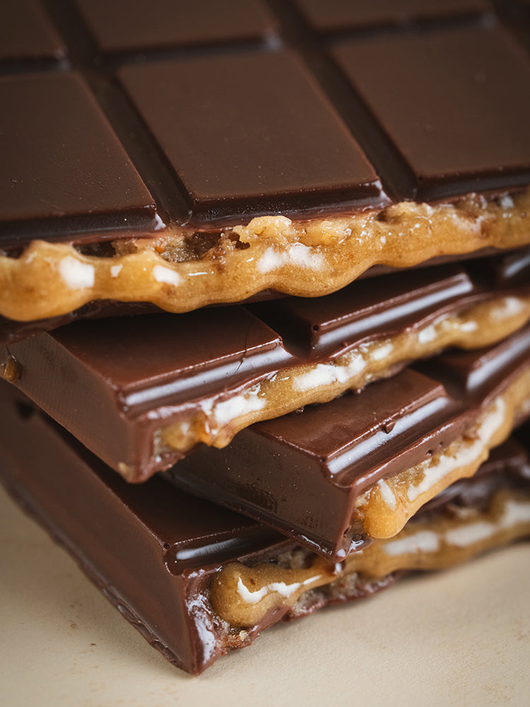 Close-up of a chocolate bar with a crumbly texture on a light background