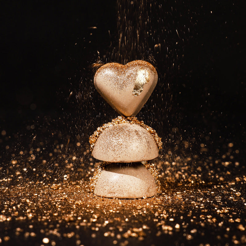 Luxury chocolates stacked on top of each other and glistening with gold