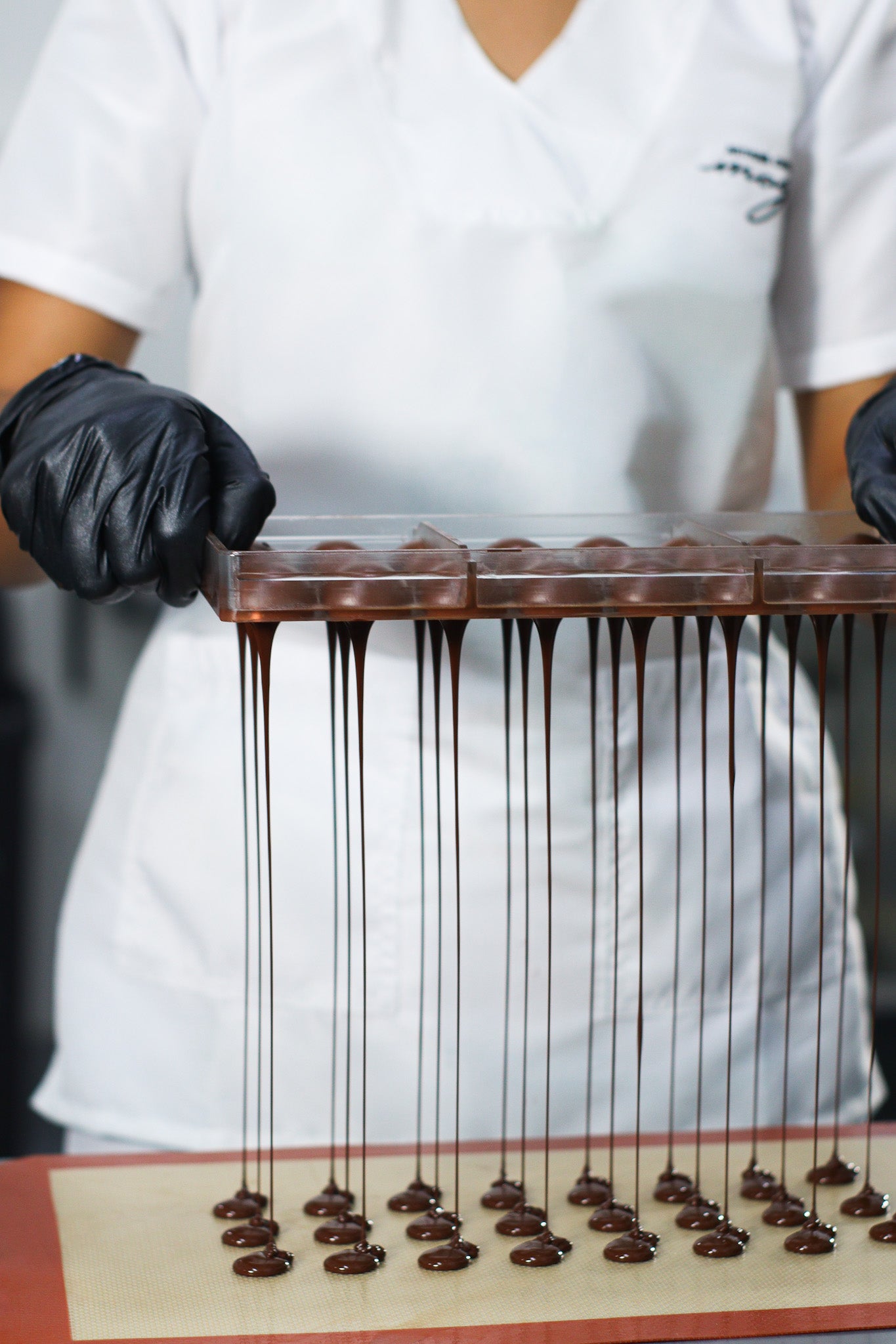 Single origin Colombian chocolate dripping from a Chocolate mold. 