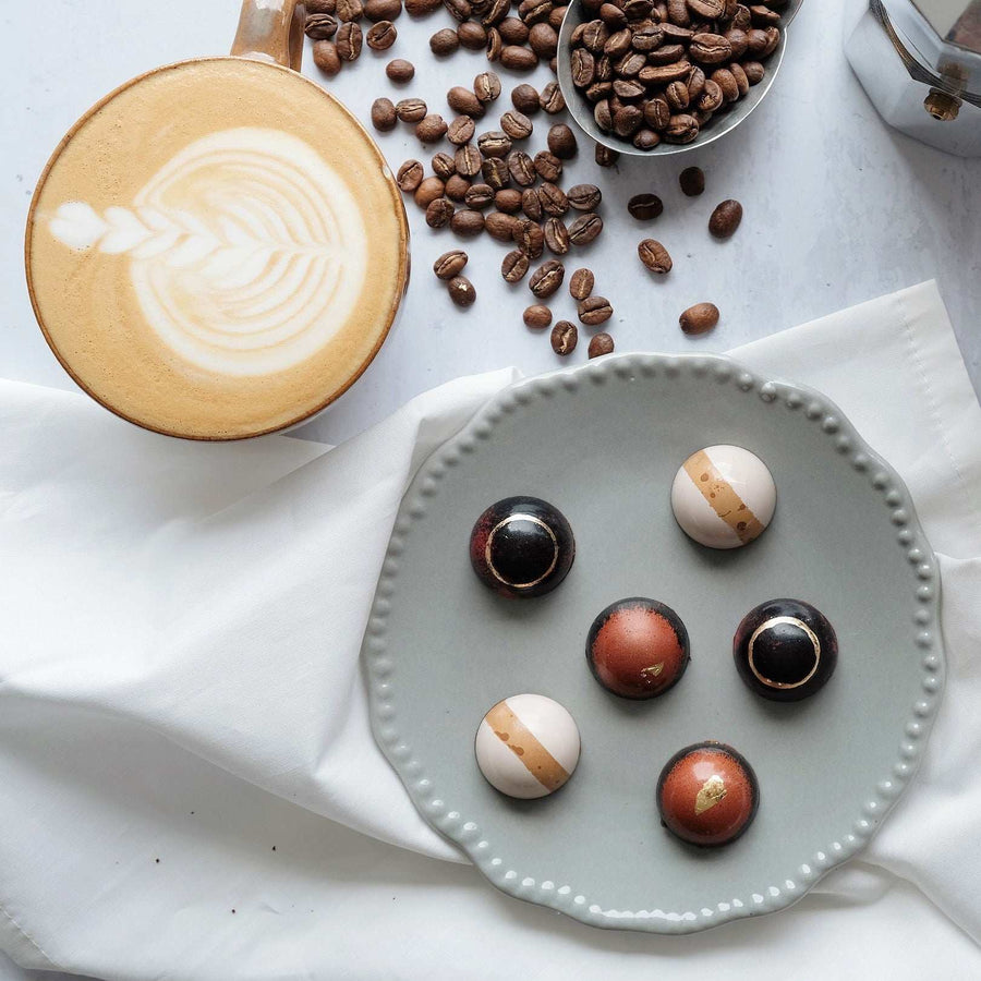 Colombian coffee grounds and artisan chocolates shown on a tabletop